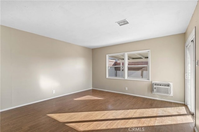 empty room with wood-type flooring and a wall unit AC