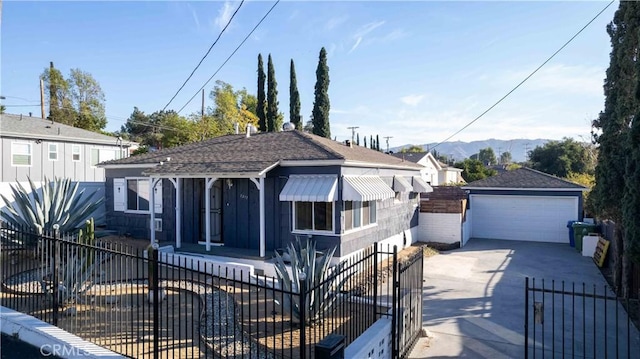 bungalow-style home with a mountain view, a garage, and an outbuilding