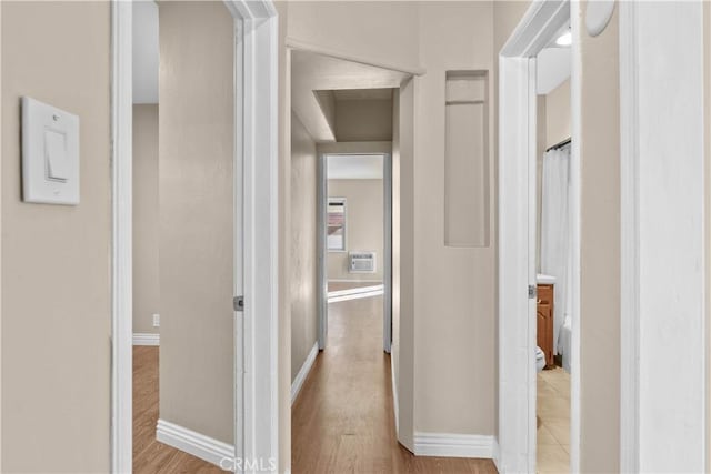 hallway featuring a wall mounted AC and light hardwood / wood-style floors