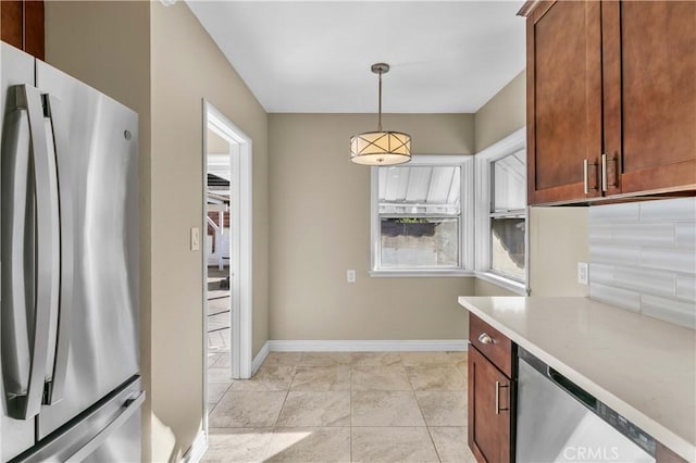 kitchen featuring light stone countertops, appliances with stainless steel finishes, decorative backsplash, pendant lighting, and light tile patterned flooring