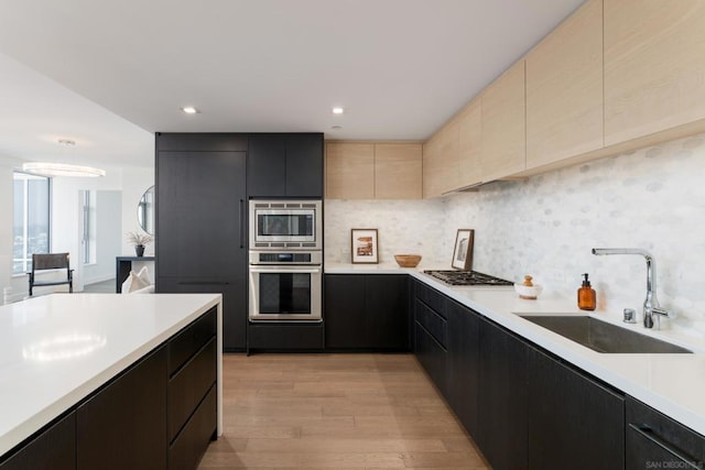 kitchen with decorative backsplash, sink, stainless steel appliances, and light wood-type flooring