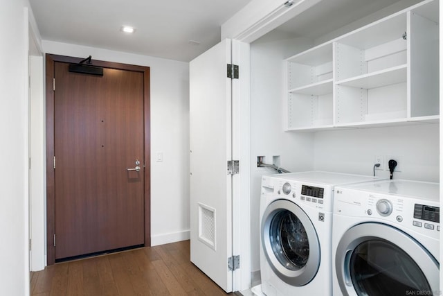 clothes washing area with washer and dryer and dark hardwood / wood-style floors