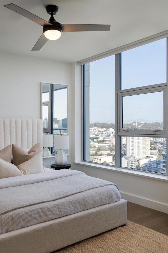 bedroom featuring multiple windows, ceiling fan, and wood-type flooring