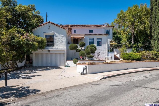 mediterranean / spanish home featuring a garage