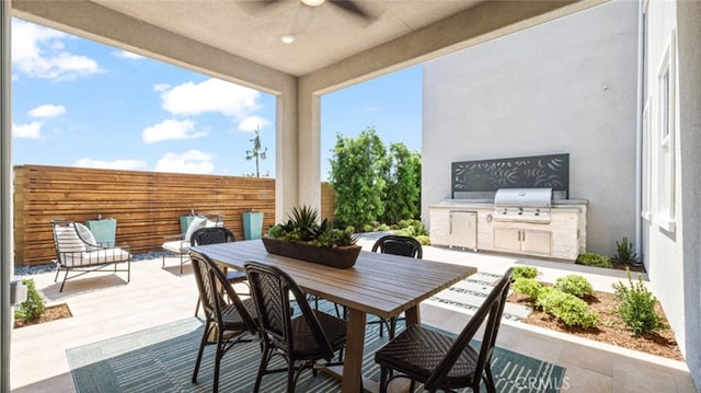 view of patio with area for grilling, ceiling fan, and a grill