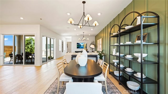 dining room with light hardwood / wood-style floors and an inviting chandelier