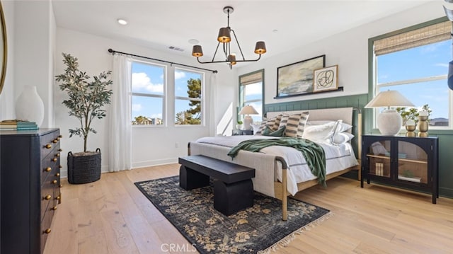 bedroom featuring light hardwood / wood-style floors and an inviting chandelier