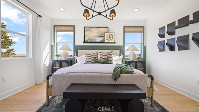 bedroom featuring light wood-type flooring and a notable chandelier