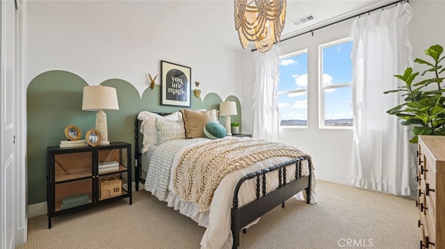 bedroom featuring light carpet and a notable chandelier