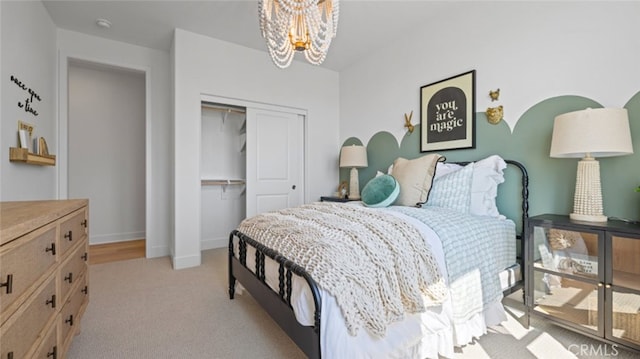 bedroom featuring light carpet, a closet, and a notable chandelier