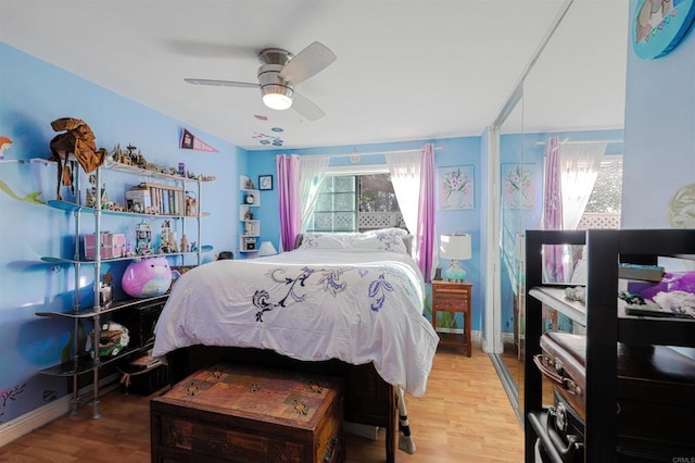 bedroom with ceiling fan, hardwood / wood-style floors, and multiple windows