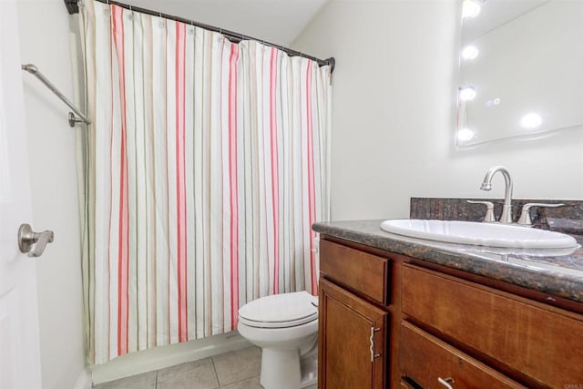 bathroom with toilet, vanity, and tile patterned flooring