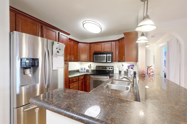 kitchen featuring kitchen peninsula, appliances with stainless steel finishes, sink, and pendant lighting