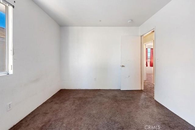 empty room with plenty of natural light and dark carpet