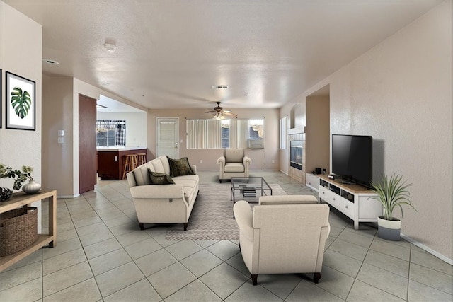 tiled living room with ceiling fan and plenty of natural light