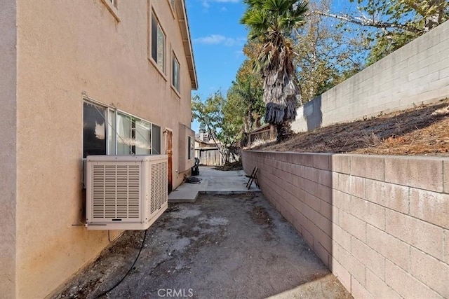 view of side of property with cooling unit and a patio