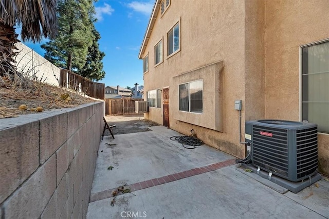 view of side of property with a patio area and cooling unit