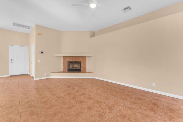 unfurnished living room with a fireplace, light tile patterned floors, and ceiling fan