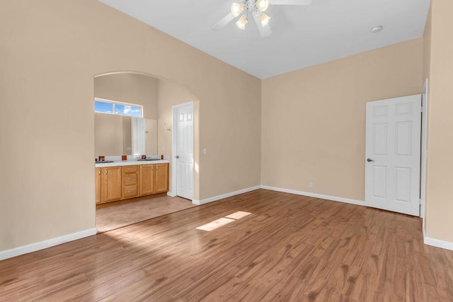 interior space featuring connected bathroom, light hardwood / wood-style floors, and ceiling fan