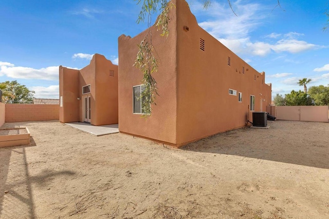 rear view of property with central AC