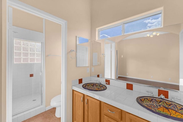 bathroom featuring tile patterned flooring, vanity, toilet, and a healthy amount of sunlight