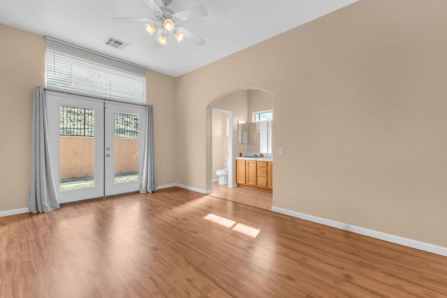 empty room with french doors, light hardwood / wood-style flooring, and ceiling fan