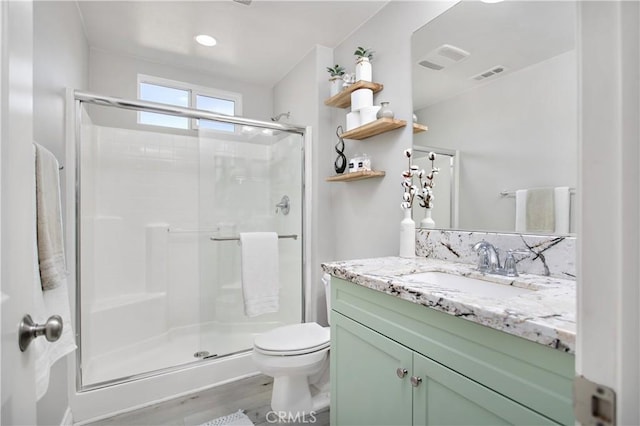 bathroom featuring hardwood / wood-style floors, vanity, toilet, and a shower with door