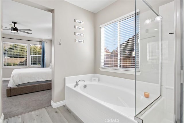 bathroom featuring hardwood / wood-style floors, shower with separate bathtub, and ceiling fan