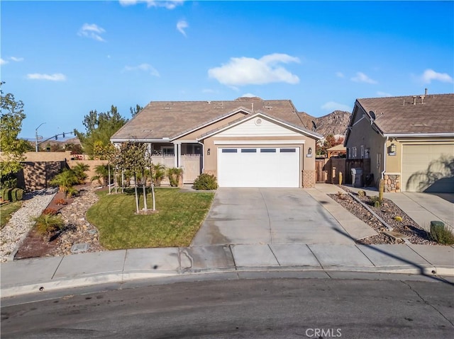 single story home with a mountain view, a garage, and a front lawn