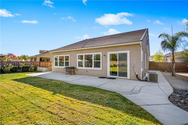 back of property with a patio area, a yard, and central AC