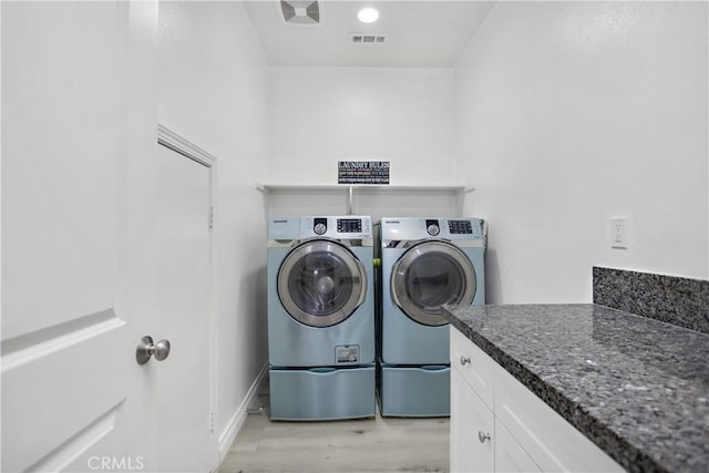 washroom featuring light hardwood / wood-style flooring and washing machine and clothes dryer