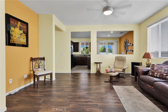 living room with dark hardwood / wood-style flooring, plenty of natural light, and ceiling fan