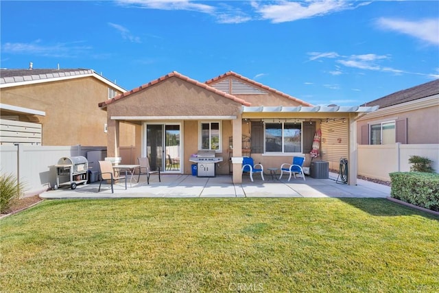 rear view of property with a lawn, central air condition unit, and a patio