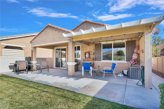 rear view of house with cooling unit, a patio area, and a yard