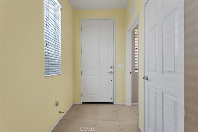 doorway to outside with light tile patterned flooring