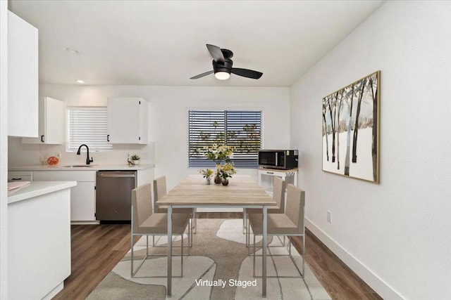 dining room featuring ceiling fan, dark hardwood / wood-style flooring, and sink