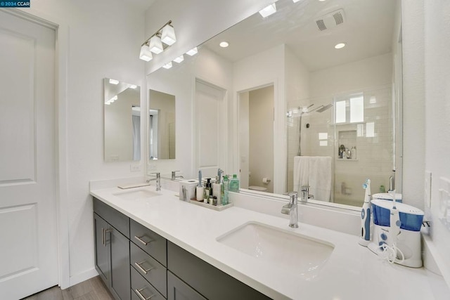 bathroom featuring vanity, hardwood / wood-style flooring, toilet, and a shower with door