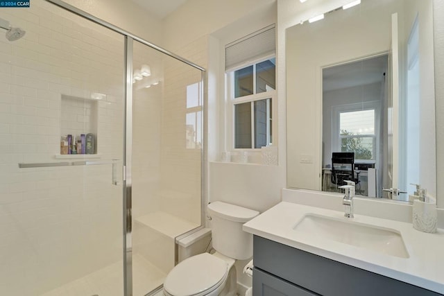 bathroom featuring vanity, toilet, and an enclosed shower