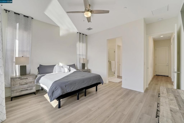 bedroom featuring ceiling fan, light wood-type flooring, and ensuite bath