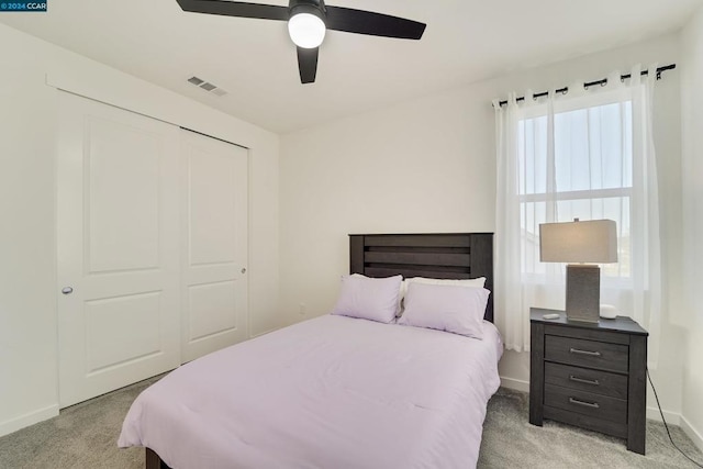 carpeted bedroom featuring ceiling fan and a closet