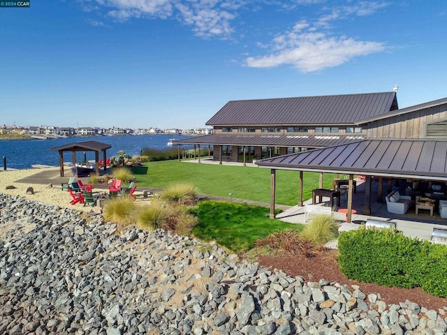 view of property's community with a gazebo, a yard, and a water view