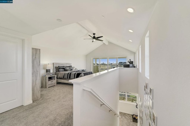 corridor with vaulted ceiling with beams and light colored carpet