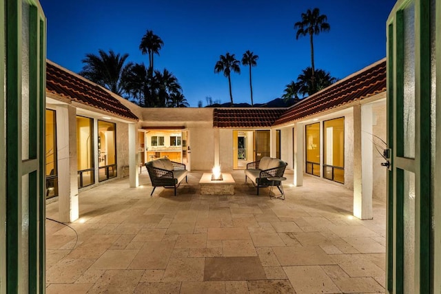 patio terrace at dusk featuring an outdoor fire pit