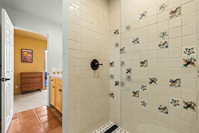 bathroom featuring tile patterned floors, vanity, and a tile shower