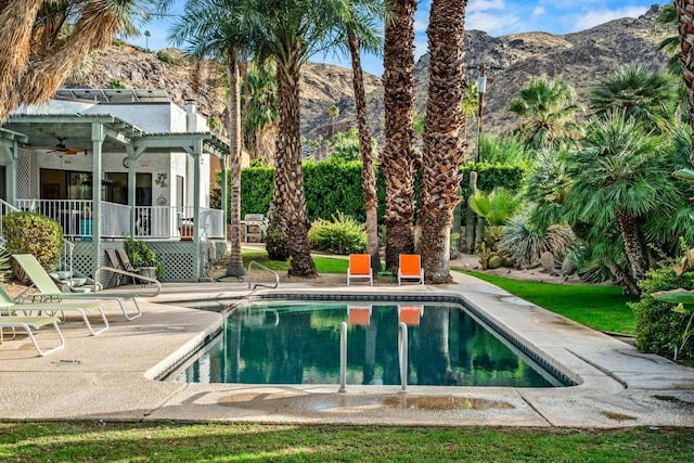 view of swimming pool with a pergola, a patio area, a mountain view, and ceiling fan