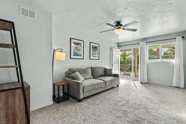 living room featuring carpet, a textured ceiling, and ceiling fan