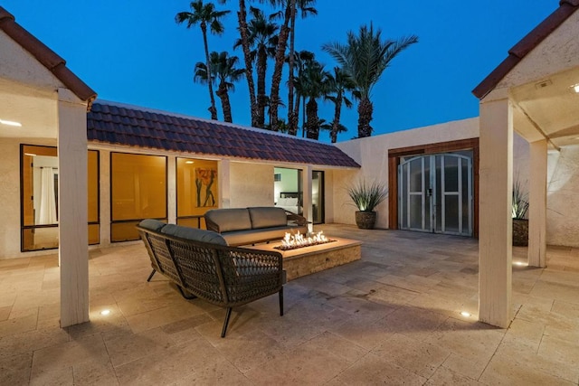 patio terrace at dusk featuring an outdoor living space with a fire pit