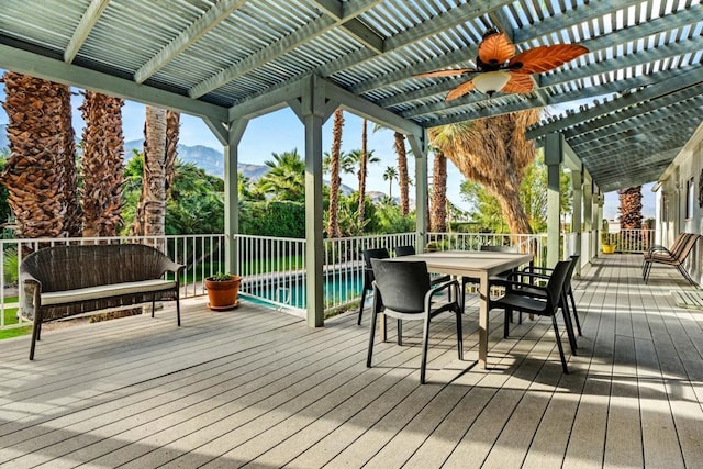 deck featuring ceiling fan, a fenced in pool, a pergola, and a mountain view