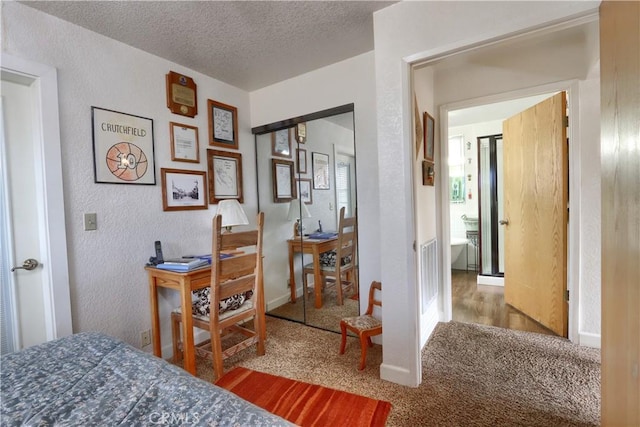 carpeted bedroom featuring a textured ceiling and a closet