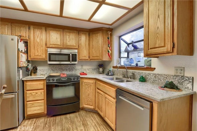 kitchen featuring sink, appliances with stainless steel finishes, and light hardwood / wood-style flooring